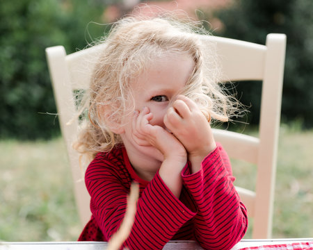 cute little girl hiding behind her hair