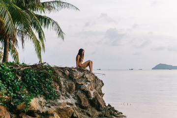 Woman sitting on rocks at the beach