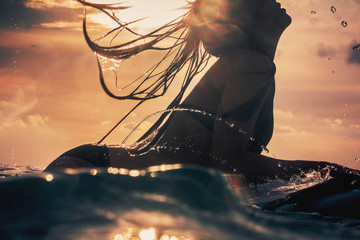 Woman's silhouette, sunset surf in Bali