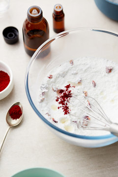Mixture of baking sofa, rose petals and essential oils in bowl.
