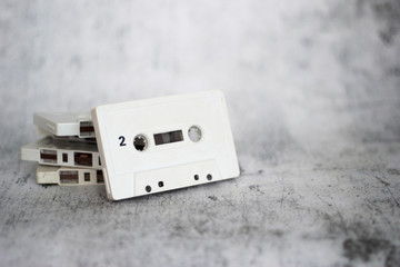 Stacked white cassette tapes on gray background