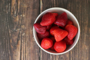 top view strawberries in bowl on wood background
