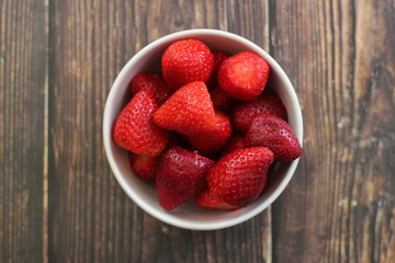 top view strawberries in bowl on wood background