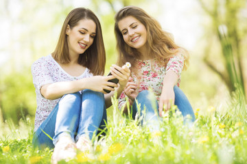 Beautiful young women looking at phone and smiling