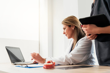 Doctor working with her laptop in dental clinic.