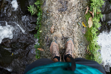 View from above of body parts of adventurer trekking through jungle.