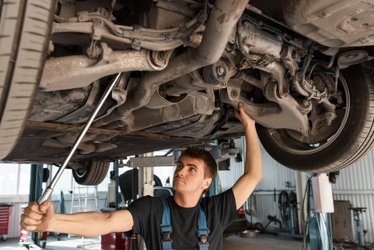 Mechanic working with car on lift