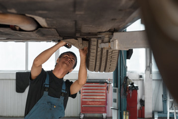 Mechanic exploring car bottom