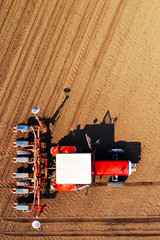 Top view of tractor with seeder from drone pov