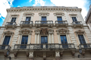 Fototapeta na wymiar Catania baroque architecture in a historic building, yellow facade and balcony