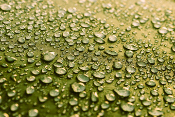 Rain water droplets on green color fiber waterproof fabric. Green background.
