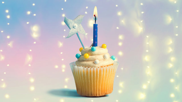 Celebratory cupcake with a decorative lit candle