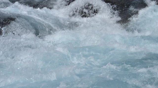 Blue glacial river rapids over rocks slow motion Iceland sunny day.mov
