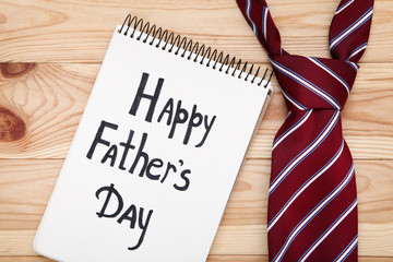 Text Happy Fathers Day with necktie on brown wooden table