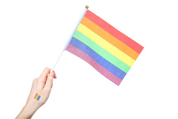 Female hand holding rainbow flag on white background
