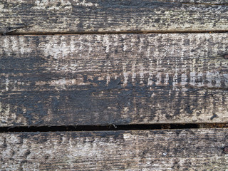 old rough wooden horizontal boards stained with black resin