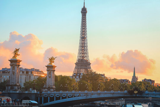 Eiffel Tower at sunset in Paris, France. Romantic travel background. Eiffel tower is traditional symbol of paris and love.