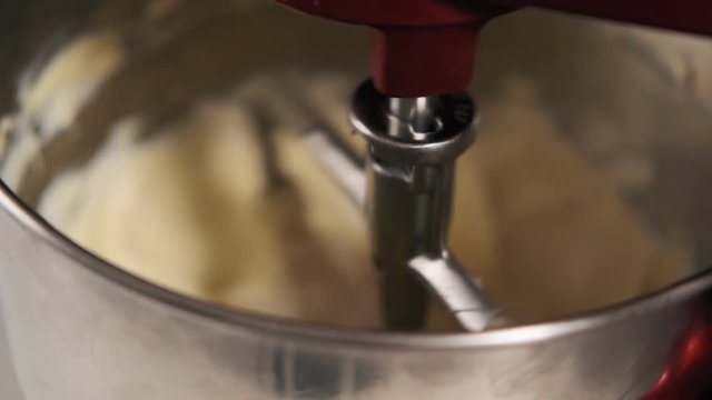 Step by step. Electronic mixer blending ingredients into cream. Mixing cream for cake in red electric kitchen mixer.