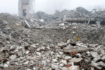 A huge pile of gray concrete debris from piles and stones of the destroyed building. The impact of the destruction.