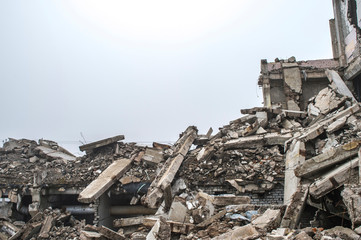 A huge pile of gray concrete debris from piles and stones of the destroyed building. The impact of...