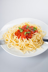 Macaroni with tomato sauce on white background
