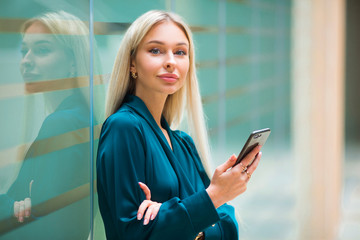 beautiful young woman with flowing white hair with a phone in her hand at work in an office