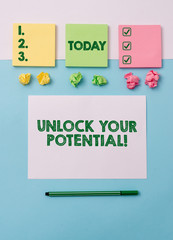 Writing note showing Unlock Your Potential. Business concept for release possibilities Education and good training is key Note papers and stationary placed sideways on top of softhued backdrop