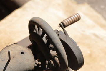 Old sewing machine, with manual drive. Covered with corrosion, dust and cobwebs. It stands on a coarse cloth.