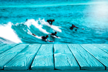 Wooden table of free space for your decoration and surfers on waves 