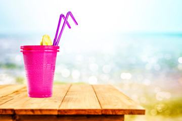 Cold summer drink on wooden table and sea landscape 
