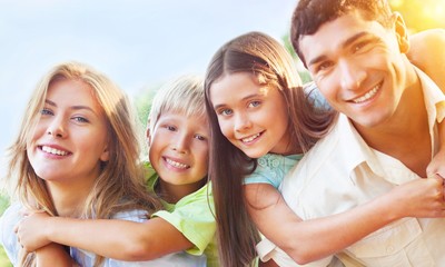 Parents Giving Children Piggybacks In Countryside