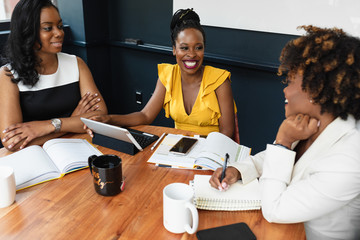 Smiling businesswomen sit in a meeting