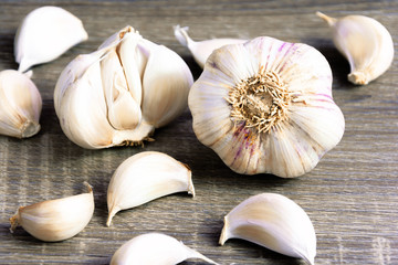 Garlic and garlic cloves on a wooden cutting board. Product photo of garlic. Healthy lifestyle. Source of antioxidants and vitamins. Vegetarian and vegan diet.