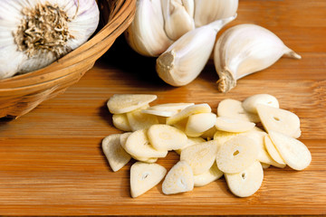Garlic and garlic cloves on a wooden cutting board. Product photo of garlic. Healthy lifestyle. Source of antioxidants and vitamins. Vegetarian and vegan diet.