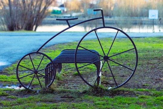 Metal construction in the form of a bicycle and parallel pipes for parking of personal bikes and scooters. Side view