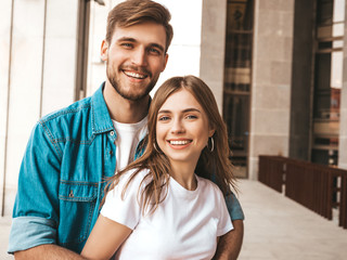 Portrait of smiling beautiful girl and her handsome boyfriend. Woman in casual summer jeans clothes. Happy cheerful family. Female having fun on the street background. Hugging