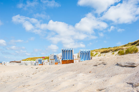 Beach in Westerland with the typical german roofed beach chairs or "Strandkorb" and white sand, Sylt island, North Sea, Germany