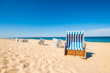 Beach in Westerland with the typical german roofed beach chairs or "Strandkorb" and white sand, Sylt island, North Sea, Germany