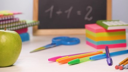 Panning shot of a school desk with different colorful supplies. Pens, pencils, markers etc. Back to school concept. 4k.