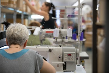 Woman sewing in workshop line area
