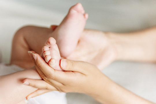 Newborn Feet In Mother's Hands. Mother And Her Child Concept.