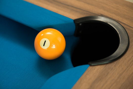 pool or billiards balls on light blue table , focus on number 1