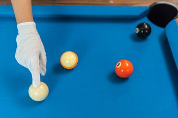 referee hand adjust pool or billiards balls on light blue table