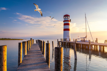 Lighthouse at Lake Neusiedl at sunset near Podersdorf with sea gulls flying around the lighthouse....