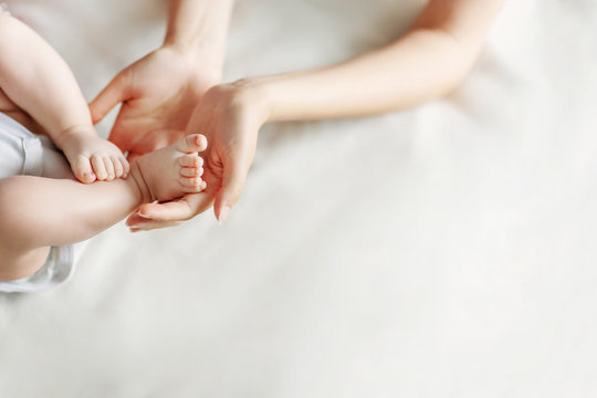 Newborn feet in mother's hands. Mother and her child concept. Copy space.