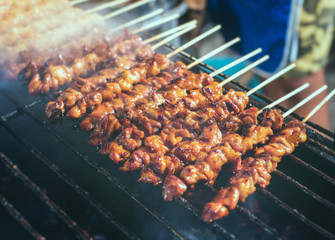 Grilled skewer chicken meat with charcoal flame.