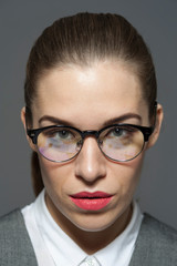 Young beautiful businesswoman or manager in glasses looks at the camera.