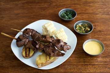anticuchos, Peruvian cuisine, grilled skewered beef heart meat with boiled potato and white corn