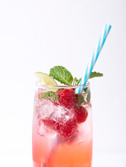 iced red raspberry punch cocktail with lime in glass on white background. summer drink.