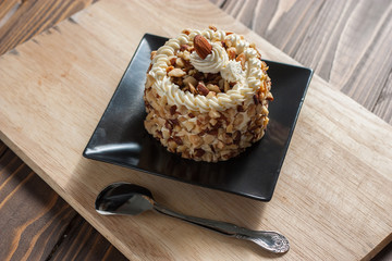 round almond cream cake on wood background